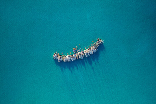 Top down aerial view of catamarans rafted together in tropical water