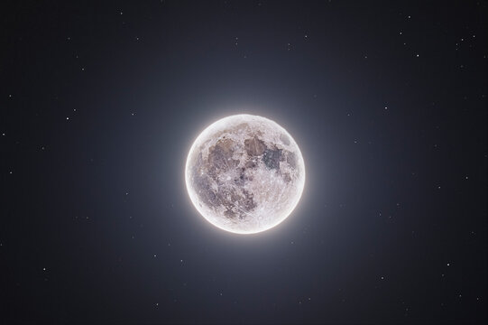 Glowing Strawberry Moon Against a Starry Night Sky