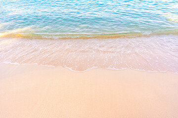 Soft blue ocean waves gently lapping onto a pristine tropical sandy beach