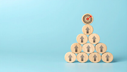 Wooden round tokens with upward arrows are stacked in pyramid shape, topped with target symbol, representing achievement, growth, and business success on blue background