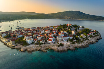 Primosten, Croatia - Aerial view of Primosten peninsula and old town on a sunny summer afternoon in Dalmatia, Croatia. Yachts, blue and golden sky at sunset by the Adriatic sea coast