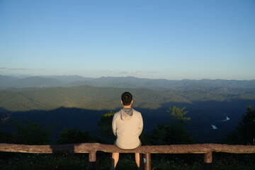 Man Sitting and Enjoying Mountain Landscape at Scenic Viewpoint