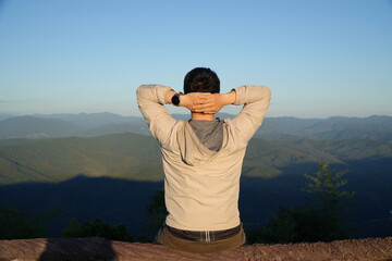 Man Sitting and Enjoying Mountain Landscape at Scenic Viewpoint