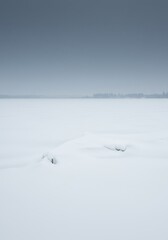 Vast silent winter landscape covered in thick white snow and crystalline ice under a frigid cold gray sky ,seasonal ,frigid ,chilling