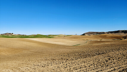 Plowed crop fields prepared for winter wheat sowing under the blue sky in the Mediterranean region