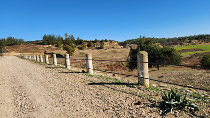 Rural dirt road with concrete post fence