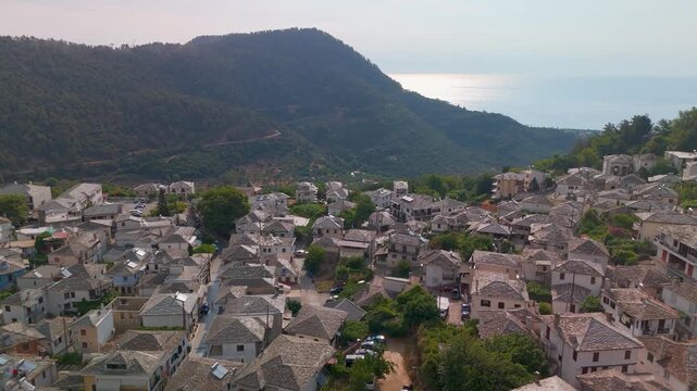 Scenic aerial pan from the traditional Panagia village and Mount Ipsarion slopes towards the Aegean Sea coastline on Thasos Island, Greece.