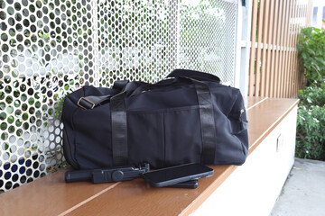 Traveler backpack with smartphone, power bank and gimbal on a wooden bench outdoors