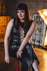 Sexy elegant beautiful gorgeous self confident plus size middle age woman in the leather black dress.