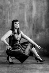 Sexy elegant beautiful gorgeous self confident plus size middle age woman in the leather black dress.