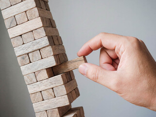 Business risk management balance concept with wooden blocks stack and hand taking one piece instability strategy structure failure goal background copy space logic game