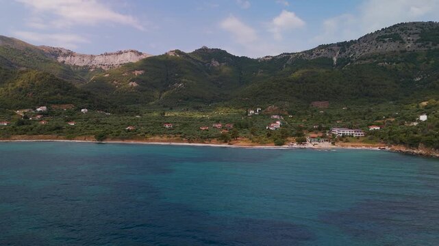 Aerial Drone Tracking Shot Panning Low Above the Water Along Kinira Beach and Forested Coastline, Thasos Island, Greece.