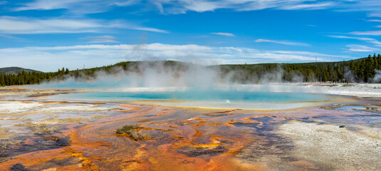 Geothermal pool under blue sky: The vibrant colors of a geothermal pool create a stunning contrast with the blue sky.
