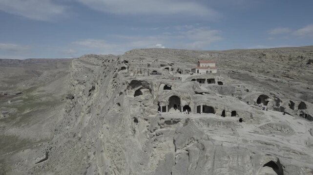 Aerial drone view of the Uplistsuli Church of the Prince in Uplistsikhe, Georgia, captured from a moderate height, revealing rock-hewn stone architecture within the ancient cave town near Gori.