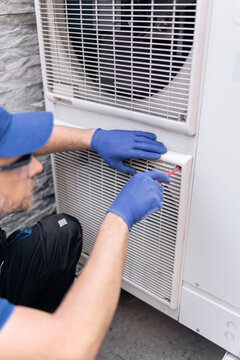 Repairman fixing AC outdoor unit.