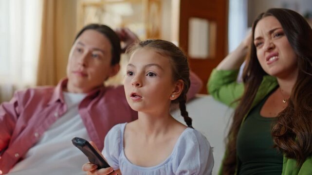 Little child holding remote controller couch closeup. Family watching movie