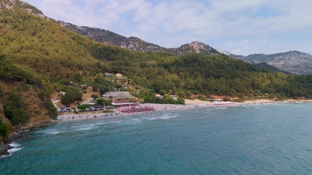 Aerial Drone Orbit Shot Circling Over Paradise Beach Near Kinira Village, Thasos, Greece, Highlighting Turquoise Aegean Sea and Summer Vacationers.
