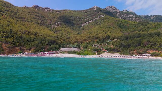 Establishing Aerial Drone Shot Panning Across Paradise Beach, Kinira, Thasos, Greece, Featuring Sunbathers and Turquoise Aegean Sea.