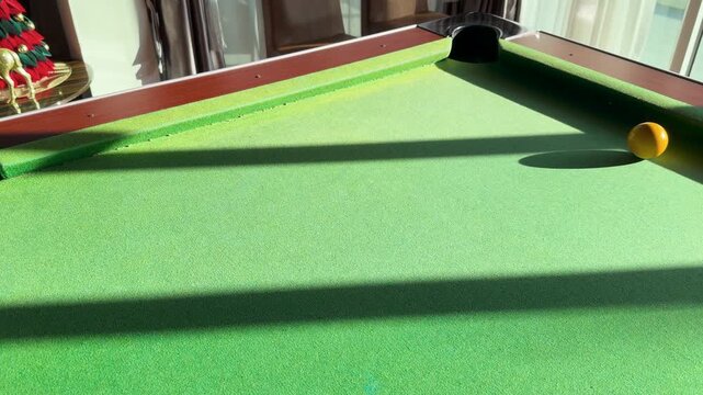 Yellow Billiard Ball Rolling Across Green Felt Table in Slow Motion