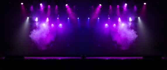 An empty stage of the theater, lit by spotlights and smoke before the performance
