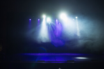 An empty stage of the theater, lit by spotlights and smoke before the performance