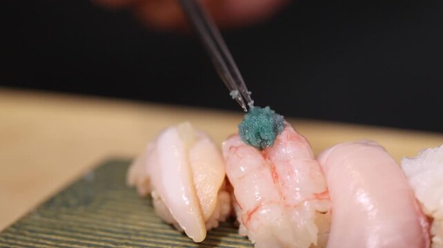 Sushi Chef Garnishing Ebi Nigiri with Green Tobiko Fish Roe