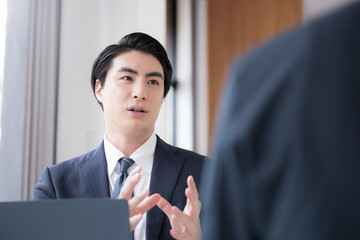 A man in a suit conducting business negotiations and sales pitches at the company, a businessman...