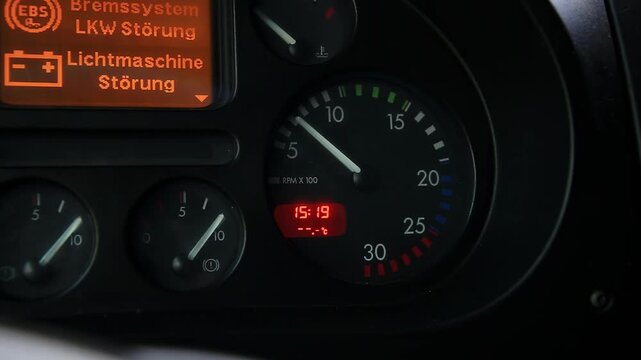 Truck dashboard. Tachometer shows engine RPM. Digital time 15:19. Warning messages. EBS brake system malfunction. Alternator fault. Critical vehicle issues visible.