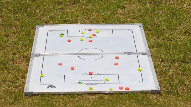 Football tactics board showing player positions during practice at a field in summer