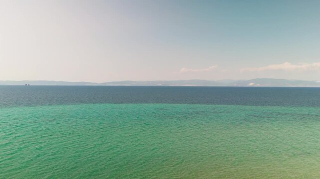 Aerial Drone Shot Rising Up from Prinos Beach, Thasos, Greece, Showcasing White Sand, Turquoise Thracian Sea, and the Greek Mainland on the Horizon.