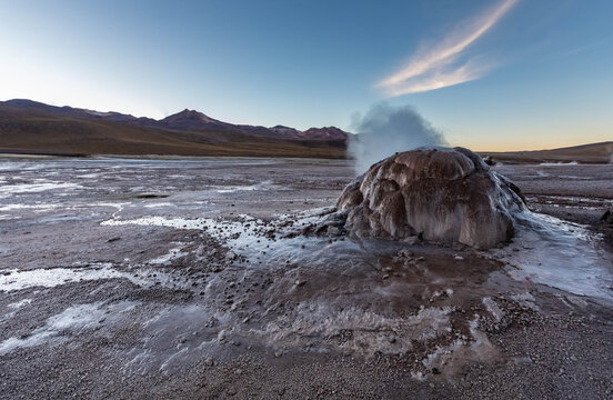 Geysir erupting at El Tatio in Chilean Andes before sunset