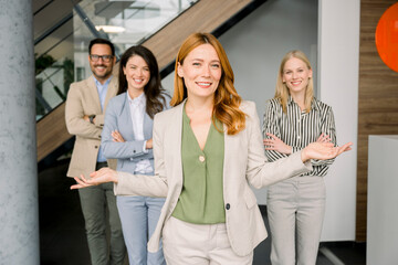 Confident business team standing and smiling in modern corporate office