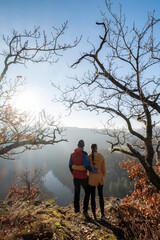 A couple in love stands in an embrace on a viewpoint above the river