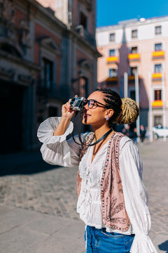Tourist photographing building at Plaza de la Villa Madrid on sunny day