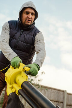 Man using a leaf blower for autumn gardening outdoors