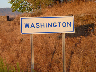 A white rectangular road sign with the word 