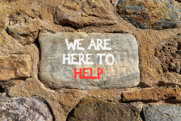 Support, help and we are here to help symbol. Concept words We are here to help on beautiful grey stone. Beautiful stone wall background. Business we are here to help concept. Copy space.