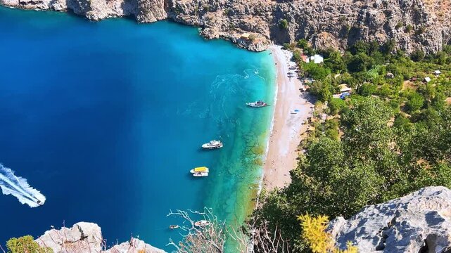 The pristine coastline and crystal clear waters of the Butterfly Valley in Oludeniz, Fethiye, Mugle, Turkey. The beach of the Valley of the Butterfly. A beach with fine white and soft sand. 4K