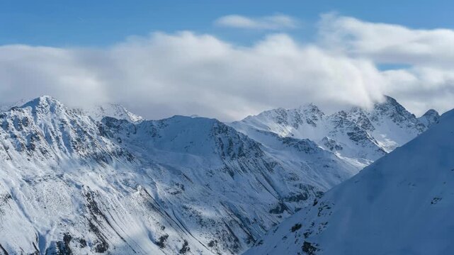 Time-lapse video from the summit of the Jakobshorn in Davos. It's winter and the clouds are drifting by. The sun is shining. A winter landscape in a winter wonderland. Clouds drifting at the peaks.