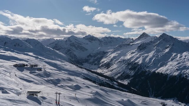 A tourist destination on the Jakobshorn in Davos. The lifts are running. The scenery is breathtaking. The mountain peaks are visible, and clouds drift across the mountain ranges.
