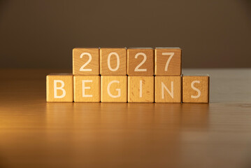 Wooden cube blocks 2027 begins background. Texts and numbers on wooden blocks with copy space. 2026 happy new year idea concept.