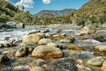 Obraz premium Rocky Mountain River with Clear Flowing Water and Scenic Landscape