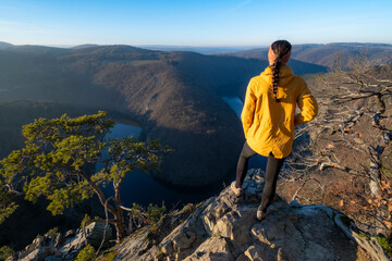 Girl standing on a stone above the Vltava River in the Czech Republic