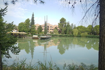 Lago di Monte Colombo con barca a vela e riflessi verdi &ndash; Rimini