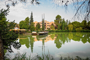 Lago di Monte Colombo con barca a vela e riflessi verdi &ndash; Rimini