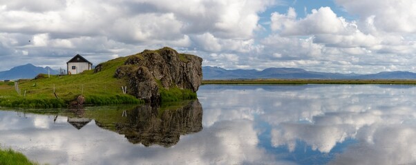 panoramic view of an abandoned house next to a lake with reflections in the water © makasana photo
