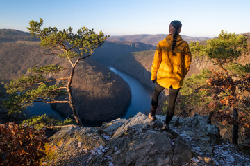 Girl standing on a stone above the Vltava River in the Czech Republic