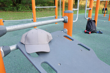 Baseball cap placed on an outdoor calisthenics workout bench in a park