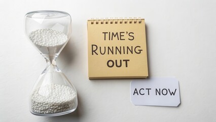 Hourglass with Time's Running Out notebook and Act Now paper