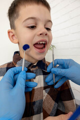 Dentist showing a boy his teeth in a mirror during a dental check-up.